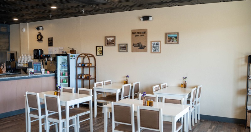 Interior seating area with white tables and chairs and decorated walls