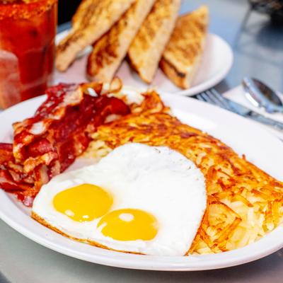 Bacon and eggs served with  hashbrowns and toast.
