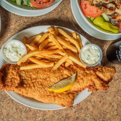 Fish and chips with tartar sauce and lemon wedge.