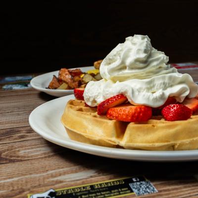 Waffle with whipped cream and strawberries.