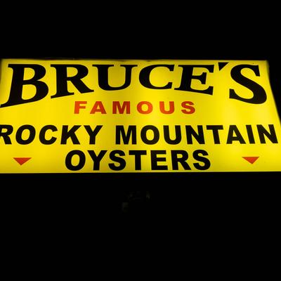 Exterior, a light sign reading Bruce's famous rocky mountain oysters.