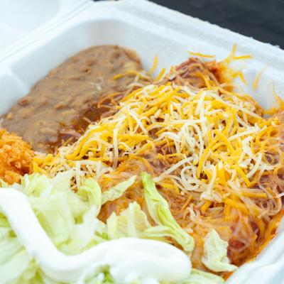 Enchiladas, with shredded cheese, salsa, lettuce, sour cream, rice, and beans.