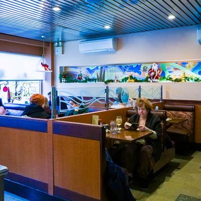 Interior with booth seating with wooden dividers and a long, decorative glass panel.