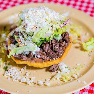 Sope with grilled steak, cheese, lettuce, and red cabbage.
