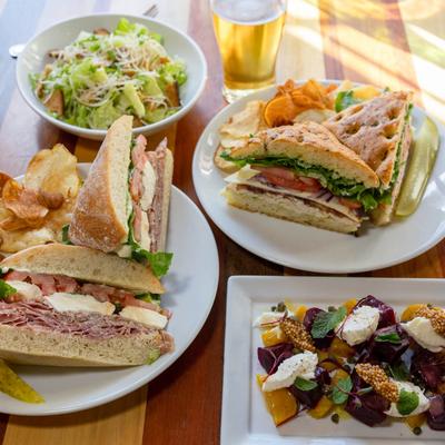 Multiple food plates and beer.