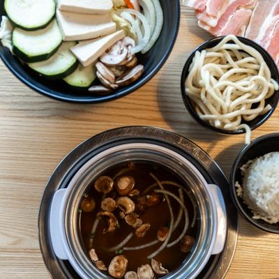 Mushroom and onion broth with tofu and veggies bowl, top view.