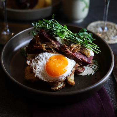 Corned beef with potato hash, cauliflower steak, and a crispy fried egg.