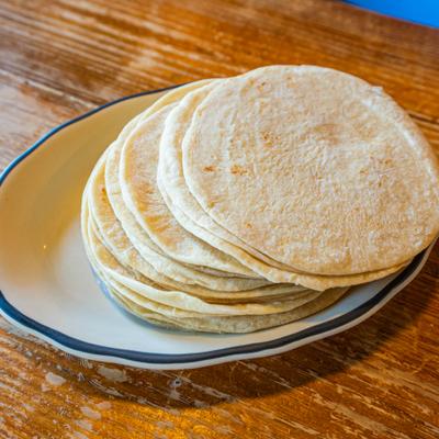 Stack of fresh tortillas served on a plate.
