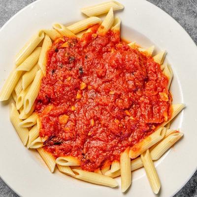 A plate of penne pasta with a red tomato-based sauce.