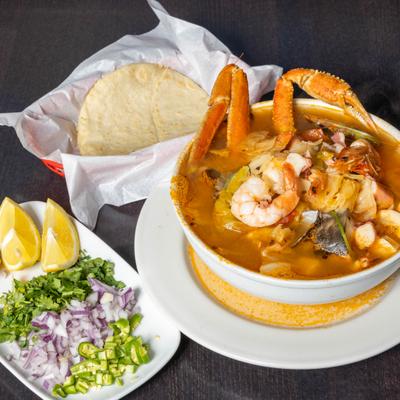 Seafood soup served with tortillas, chopped onions, cilantro, and jalapenos.