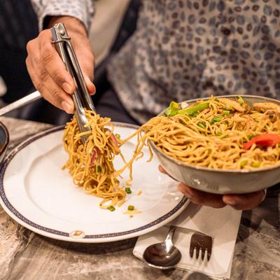 Hakka noodles being plated.