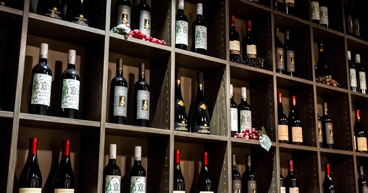 Wall of wine bottles arranged on wooden shelves