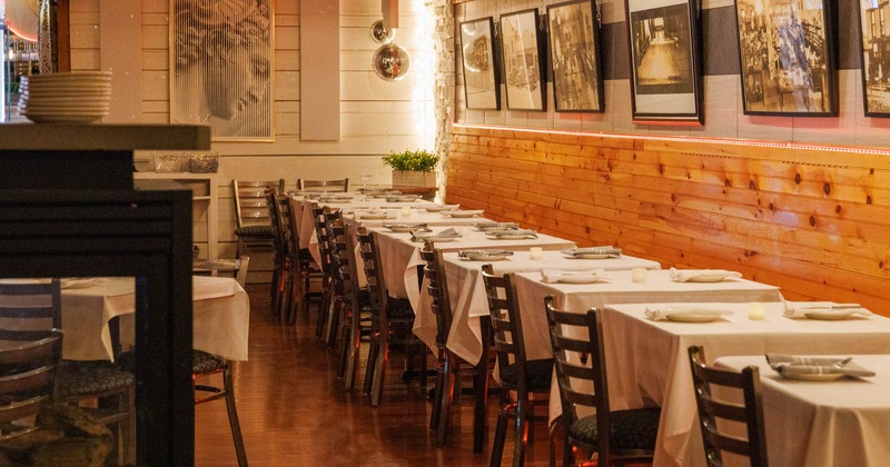 Interior, dining area, long banquette bench with tables and chairs, wood coated walls