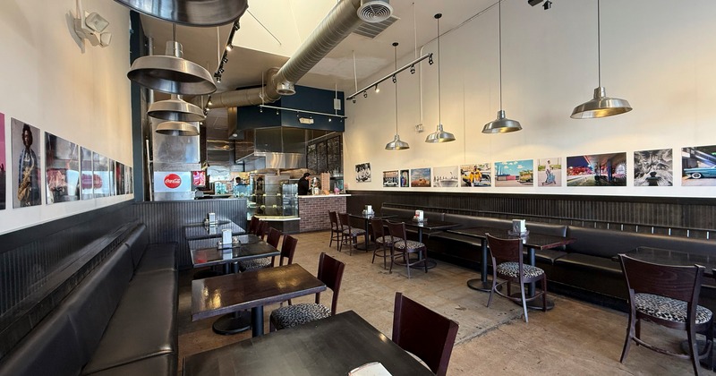 Interior, dining space with black leather benches and chrome chandeliers