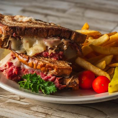 Reuben sandwich with fries and cherry tomatoes.