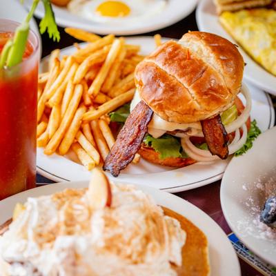 Bacon Cheeseburger with fries, alongside other menu items on the table.