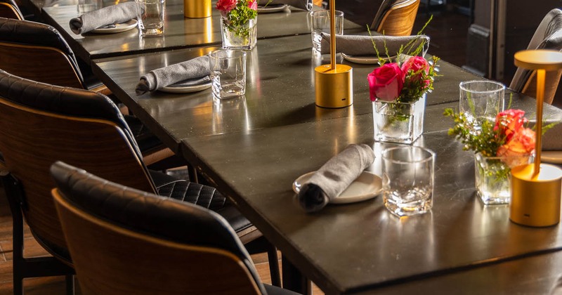 Close up of dining tables set with tableware and floral display