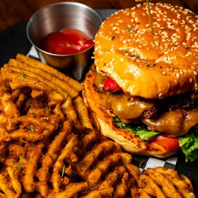 Cheeseburger with waffle fries and ketchup.