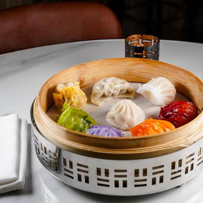 Dim sum platter with assorted dumplings, served in a bamboo steamer.