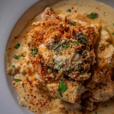 Blackened salmon with seafood mix over mashed potatoes in creamy Cajun sauce.