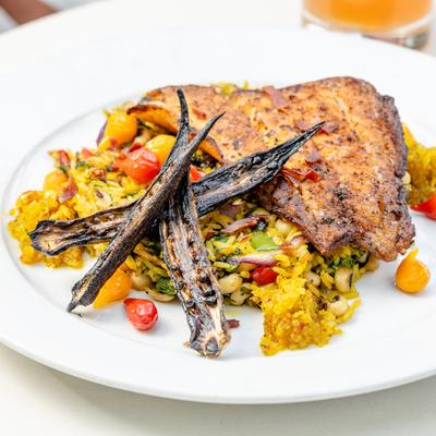 Blackened fish fillet with spiced yellow rice with okra and cherry tomatoes