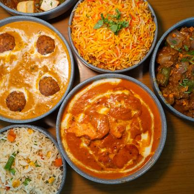 Assorted curry dishes served together with a bowl of rice.