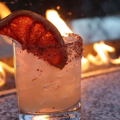 Cocktail served in a rimmed glass, garnished with dried grapefruit.