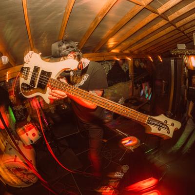 Distorted shot of a bassist on stage holding the bass in the air