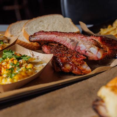 Ribs served with loaded potato, cream corn, and bread.