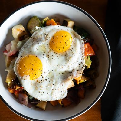 House Hash topped with two sunny side up eggs, top view.