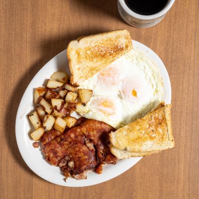 Breakfast plate with eggs, hash, potatoes and toast.