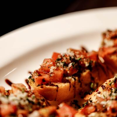 Bruschetta topped with diced tomatoes, garlic, herbs and balsamic glaze.