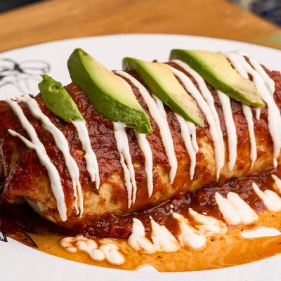 Burrito, topped with ranchero sauce, sour cream, and avocado.