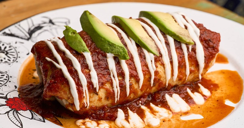 Burrito, topped with ranchero sauce, sour cream, and avocado