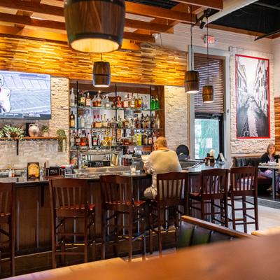 Guest seated at the restaurant bar with sticked shelves.