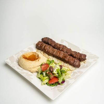 Beef Kabob, on a bed of rice, with hummus, and salad.