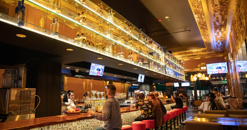 Restaurant Interior - Bar Area - Guests sitting at the bar, bartender serving drinks