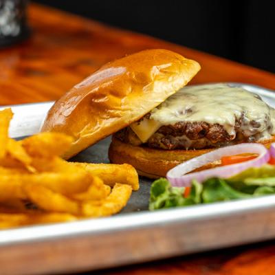 Smash burger, served with fries and side salad, closeup.