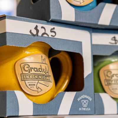 Boxed ceramic mugs with the restaurant branding.