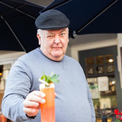 Person holding a red drink with mint.