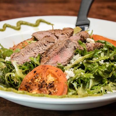 Steak salad, with tomatoes, blue cheese, lettuce, balsamic, and poblano drizzle.