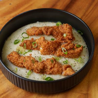 Bowl of Catfish and Grits, garnished with green onions.