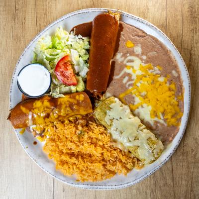 Three distinct enchiladas topped with different sauces, served rice, beans and a salad.
