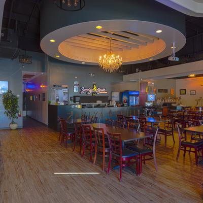 Interior, dining area, wooden tables and chairs, ordering counter in the background.