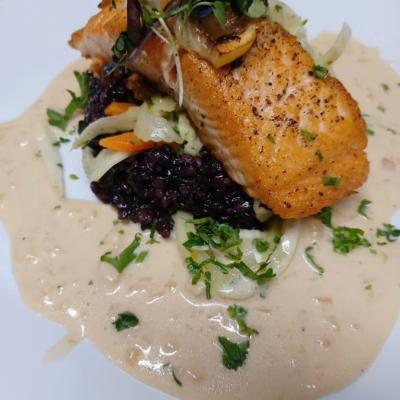 Seared salmon with veggies and sauce.