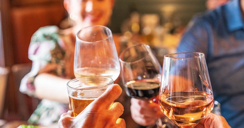 A group of people joyfully toasting with wine glasses, close up