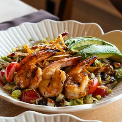Grilled shrimp salad with avocado, lettuce, tomato, corn, beans, and balsamic.