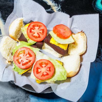 Bologna sliders topped with cheese, lettuce and tomato.