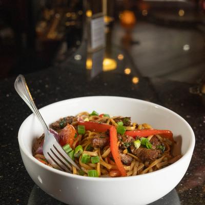 Beef noodle stir-fry with peppers and green onions.