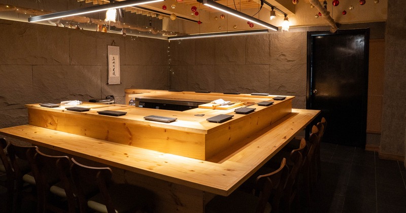 A modern sushi bar with a wooden counter and hanging ornaments